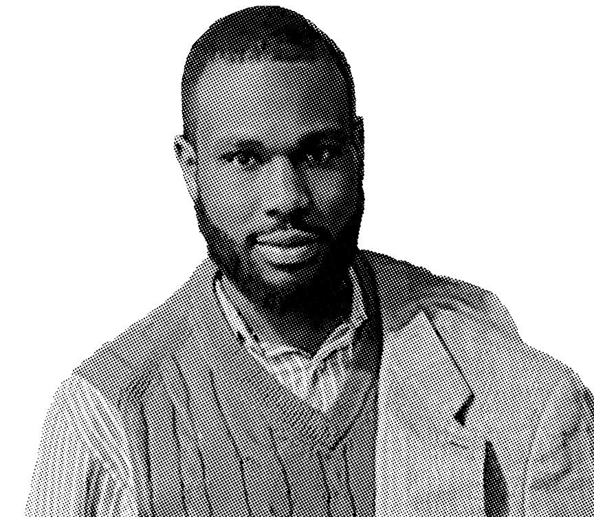 Black and white portrait of Jean Anglade wearing a checkered shirt, slightly smiling.